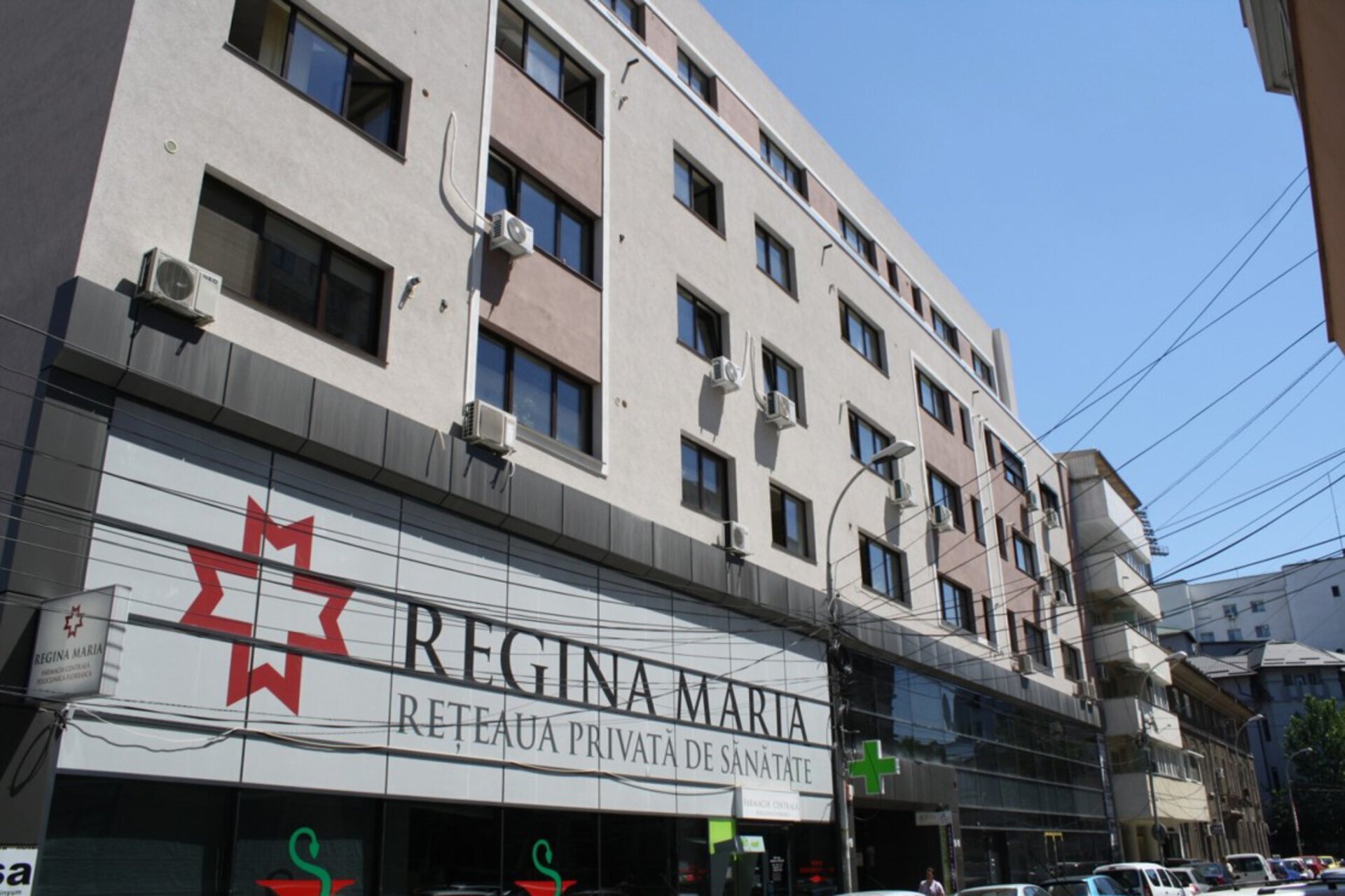 Facade of the Regina Maria Hatmanul Arbore medical center, Sector 1, with the „Reteaua Privată de Sănătate Regina Maria” sign on the ground floor and the Farmacia DONA logo within the same building, PPAE fit-out project