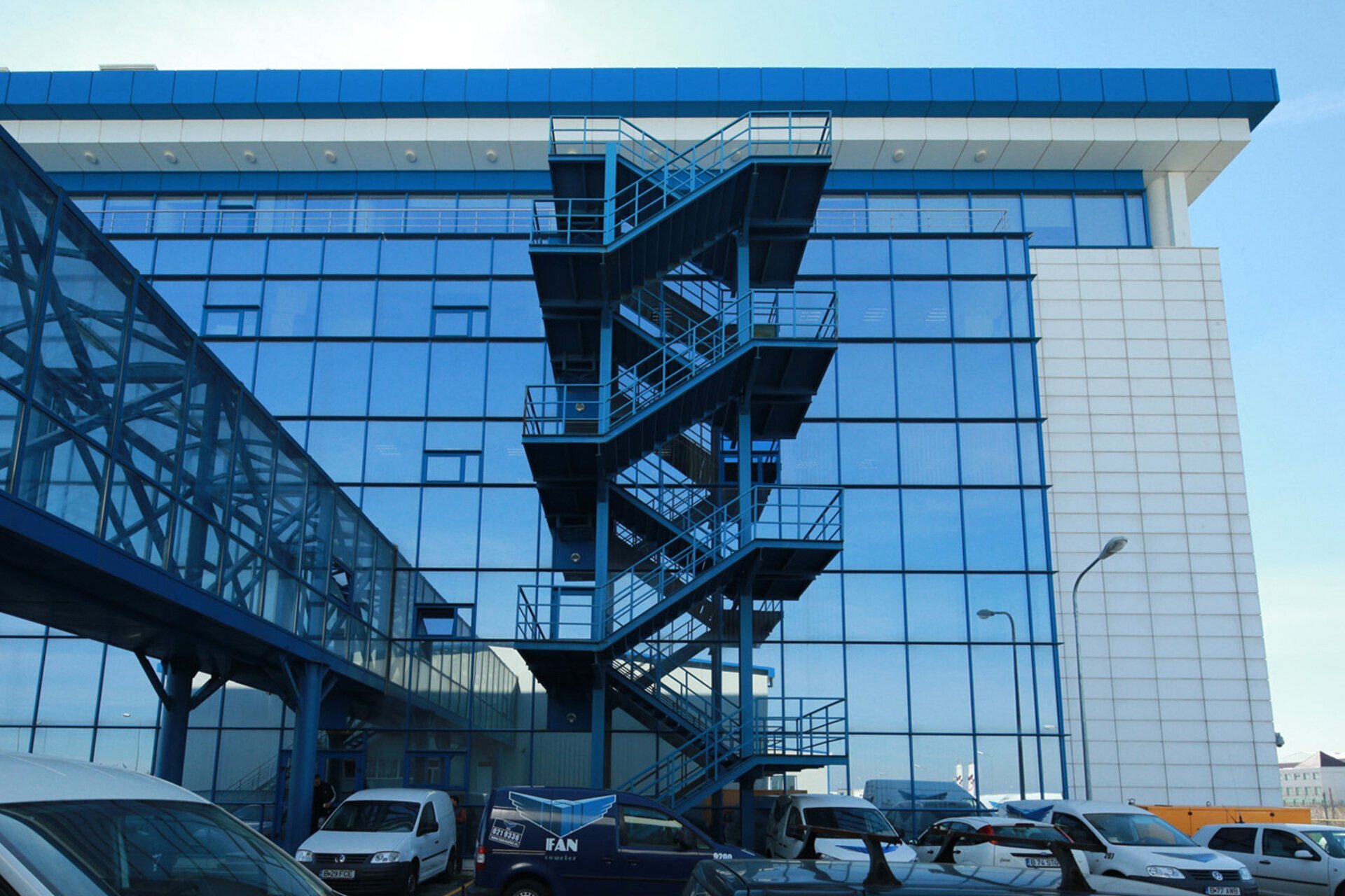 Glazed facade detail of the FAN Courier Stefanesti administrative headquarters with an exterior escape stair, PPAE project