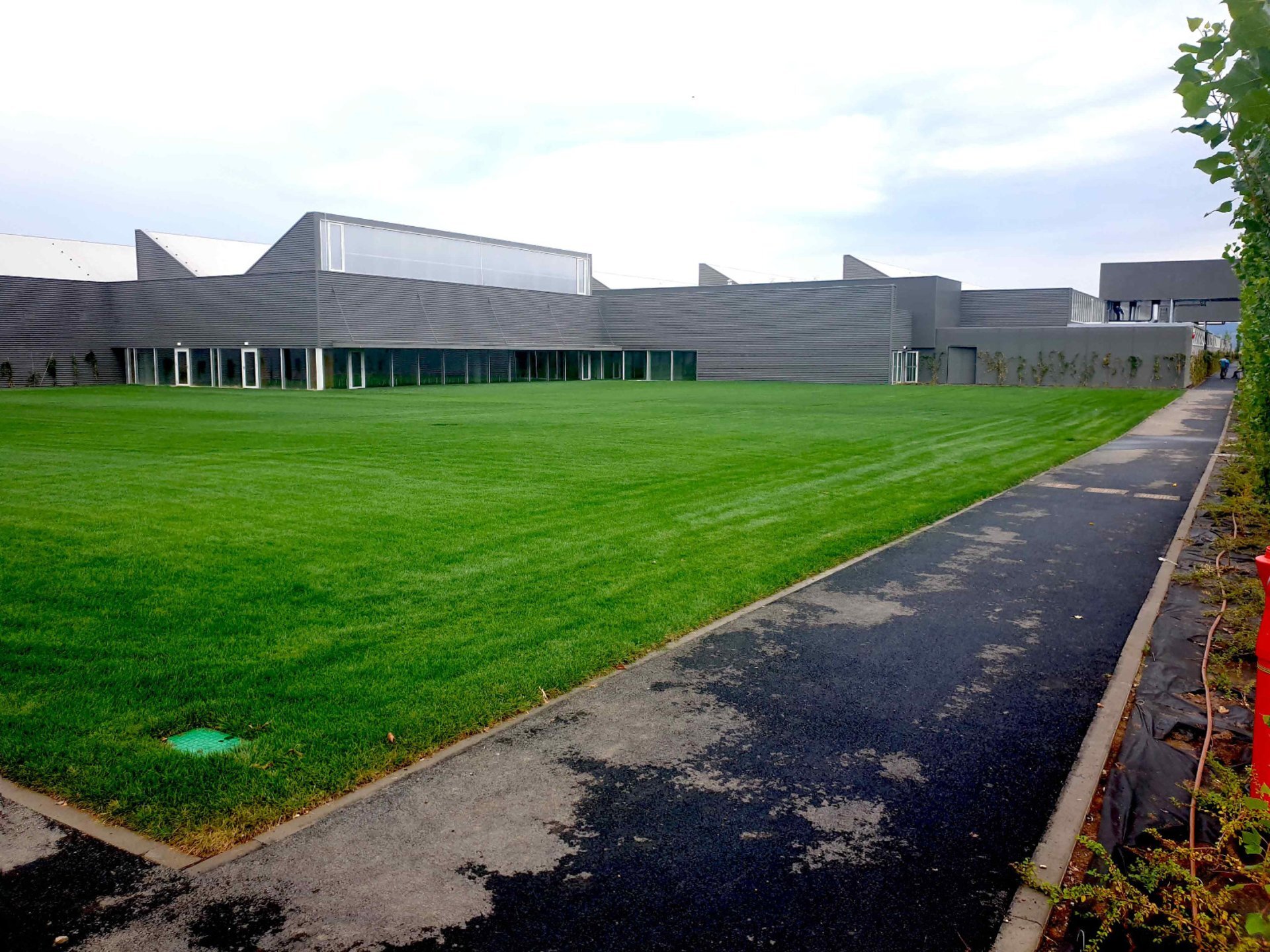 Rear facade of the Prada Sibiu factory with a roof of north-facing skylights, PPAE technical design