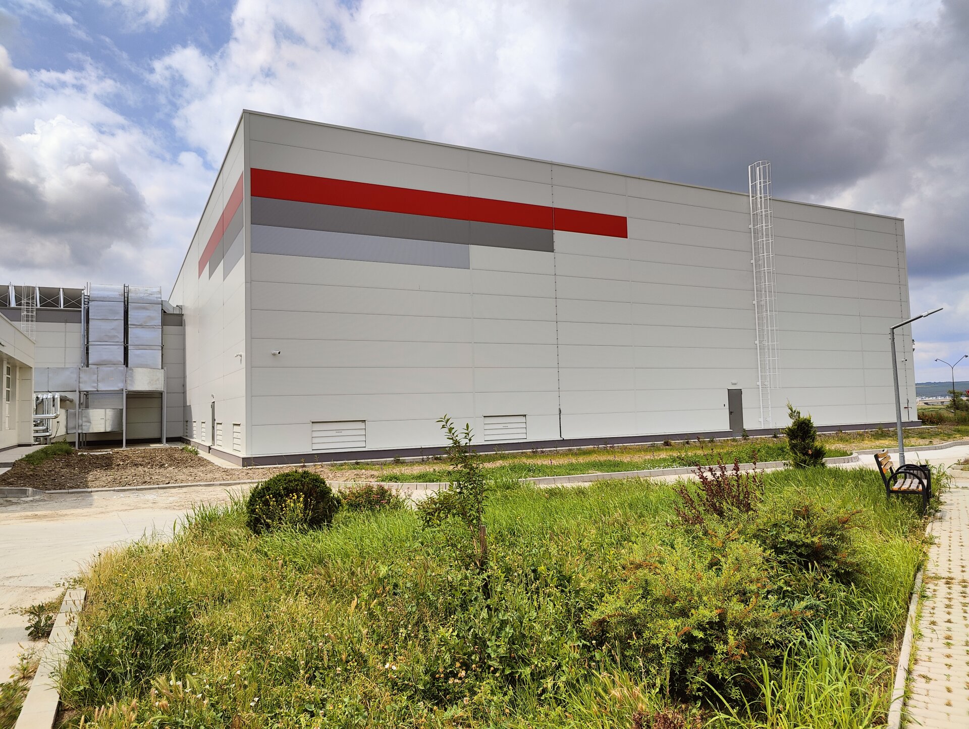Volume of Antibiotice Iasi pharmaceutical warehouse with sandwich-panel facade and chromatic accent in the brand identity, PPAE project